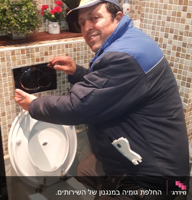 אדם מתקן ניאגרה עם מפתח ברגים בידו